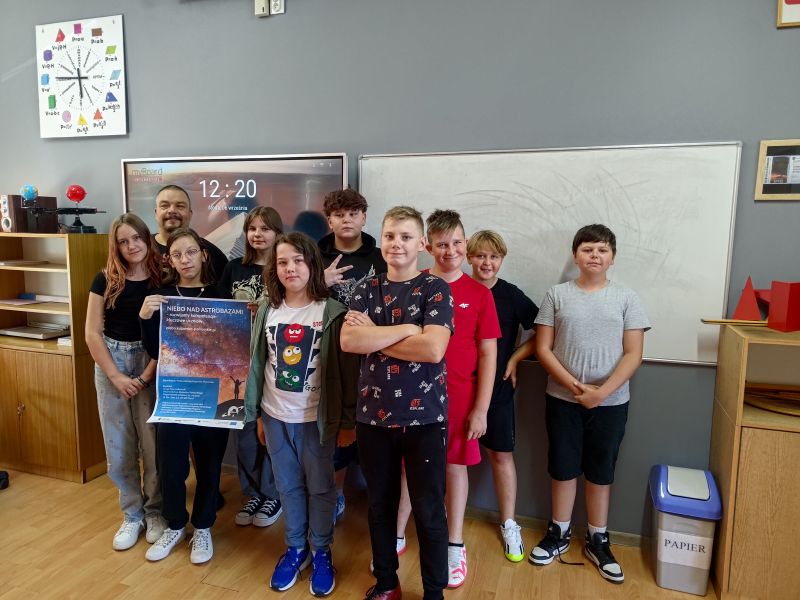 zdjęcie tytułoweUczniowie w szkole prezentują plakat projektu Niebo nad astrobazami